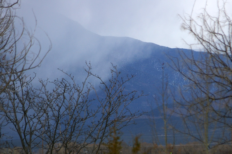 A snow shower sliding past Taos Mountain.