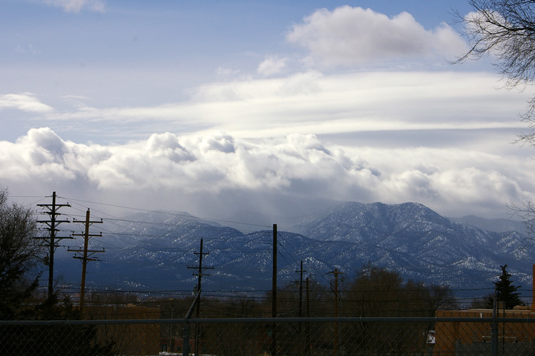 View of Picuris Peak and snow showers from the library parking lot in Taos, New Mexico.