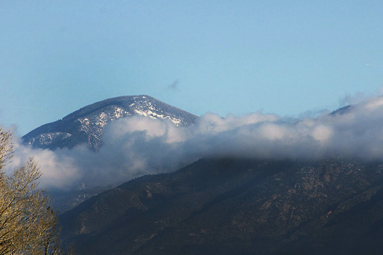 A long cloud winding its way around Taos Mountain