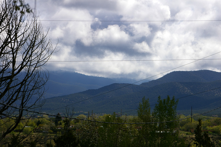 Utility lines slicing up the view of early morning clouds across the valley near Taos