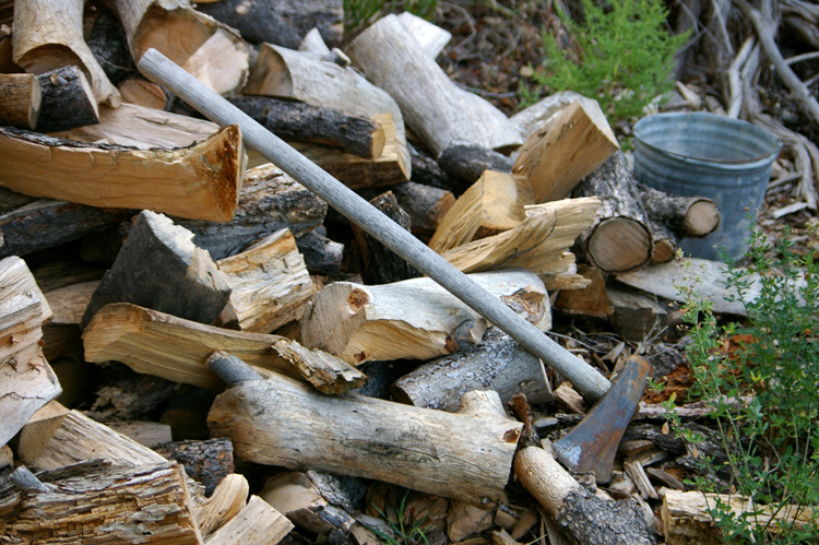 Rusty splitting maul in woodpile